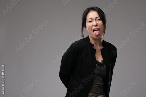Sassy rude Asian woman sticking out her tongue