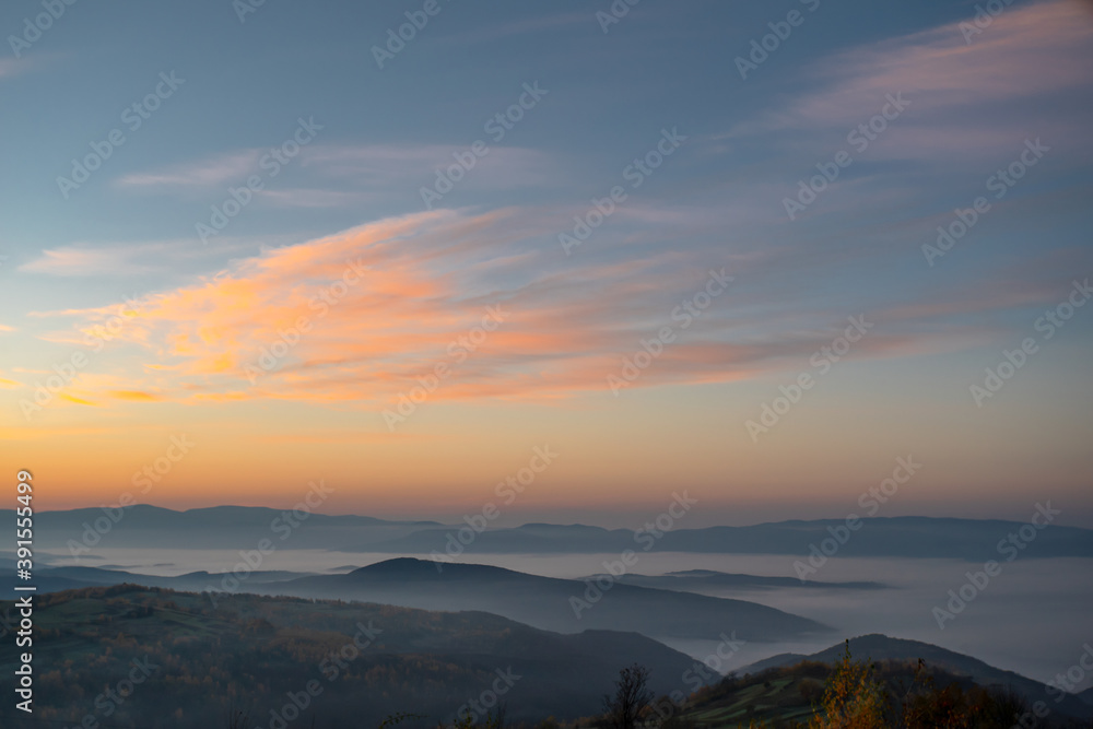 dawn cream mountains in the fog the sky shimmers with beautiful colors. Climate change from summer to autumn.