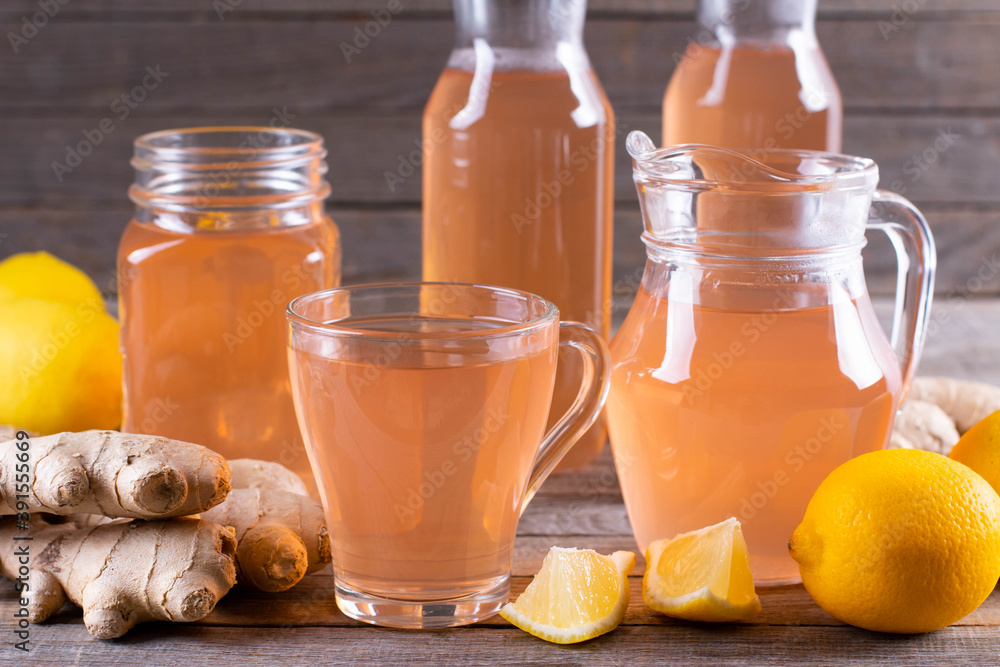 Kombucha or cider fermented drink. Cold tea beverage with beneficial bacteria, ginger, lemon on wooden table. For healthy nutrition. Kombucha or cider fermented drink. Cold tea beverage with beneficial bacteria, ginger, lemon on wooden table. For healthy nutrition.