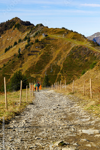 Vertical shot of hikers walking on a path in the Walmendingerhorn, Mittelberg, Austria photo