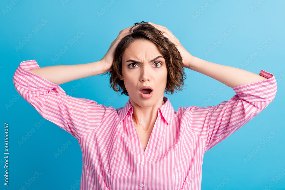 Photo of wavy shocked surprised business woman dressed pink shirt open mouth raised eyebrow arms head isolated blue color background Photo of wavy shocked surprised business woman dressed pink shirt open mouth raised eyebrow arms head isolated blue color background