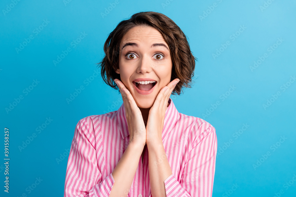 Photo portrait of cute charming business lady dressed formal pink shirt open mouth arms cheekbones isolated blue color background Photo portrait of cute charming business lady dressed formal pink shirt open mouth arms cheekbones isolated blue color background