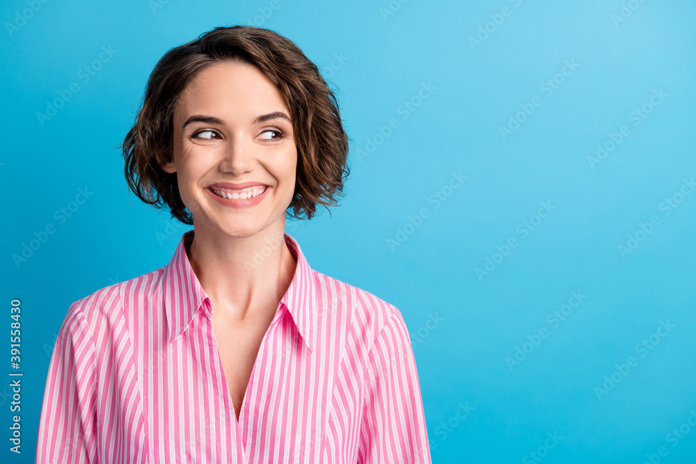 Photo portrait of curly cute shiny woman lady wear pink shirt look empty space isolated blue color background Photo portrait of curly cute shiny woman lady wear pink shirt look empty space isolated blue color background