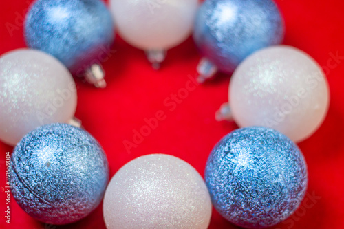 Christmas decorations on a red background. Holiday decorations. Christmas concept. White and blue Christmas decorations lie in the shape of a circle