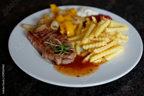 roasted steak with french fries and paprika