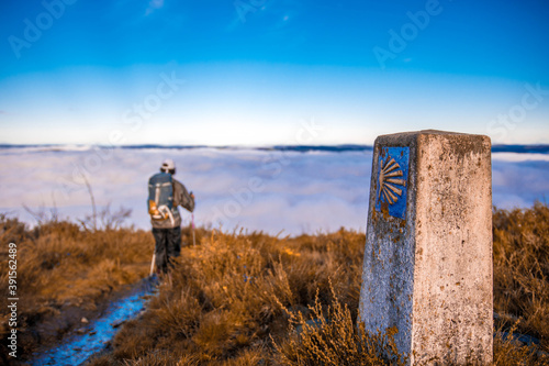 Принти на полотні Peregrino recorriendo el camino primitivo de santiago sobre un mar de nubes y co