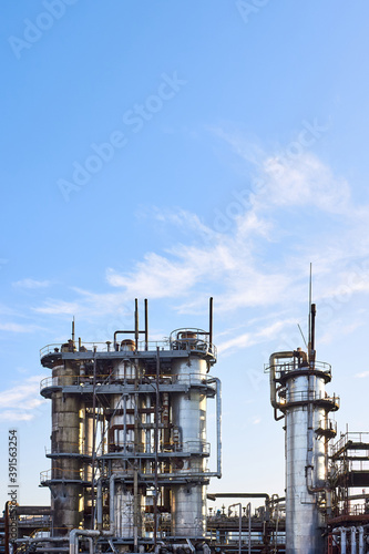 Wallpaper Mural Old distillation column towers with blue sky with clouds background at chemical plant. Exterior of silver metal rusty methanol distillation enterprise vertical with copyspace. Torontodigital.ca