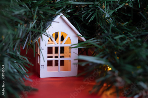 Obraz na płótnie glowing wooden houses garland on the tree. New year and christmas concept, real estate concept w salonie
