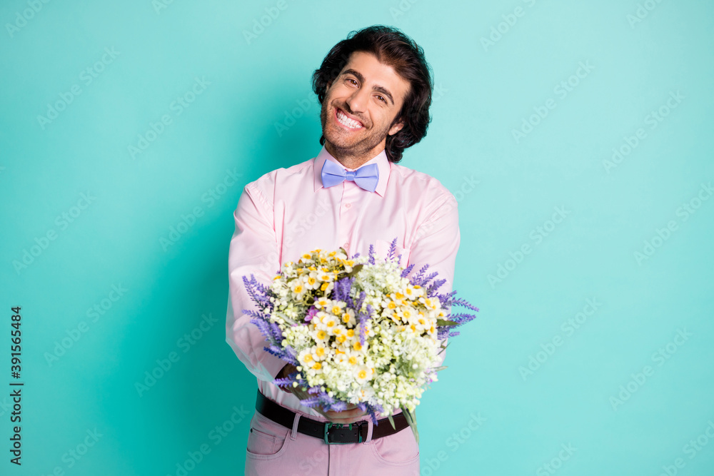 Photo of handsome beaming gentle man dressed pink outfit preparing present you bouquet beautiful flowers isolated teal color background Photo of handsome beaming gentle man dressed pink outfit preparing present you bouquet beautiful flowers isolated teal color background