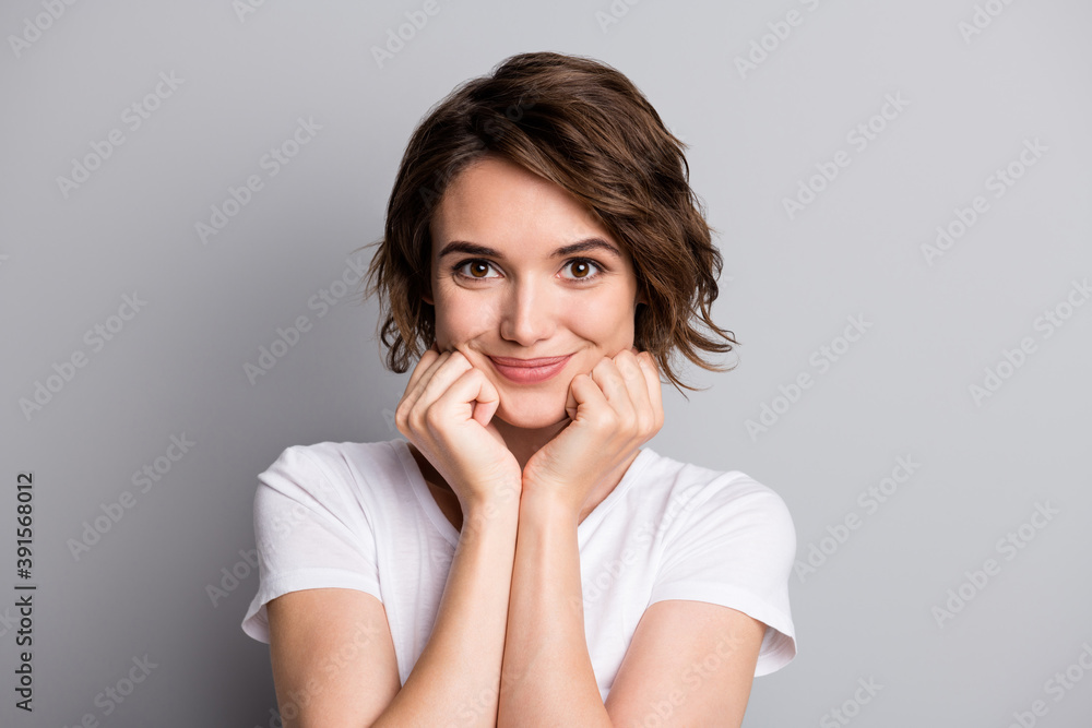Photo of young brown hair attractive positive girl enjoy smile hands touch cheekbones isolated over grey color background Photo of young brown hair attractive positive girl enjoy smile hands touch cheekbones isolated over grey color background