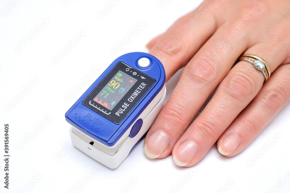 Close up of Finger in an Oximeter Device. Pulse oximeter on white background. Close up of Finger in an Oximeter Device. Pulse oximeter on white background.