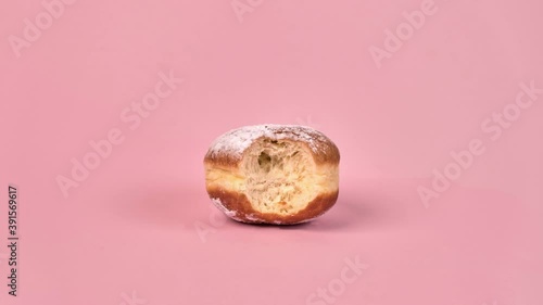 Stop motion sweet doughnut with filling. Half-eaten food., in the context of. On a pink background.
