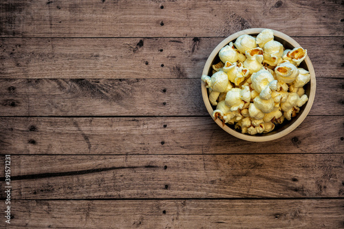 Popcorn in a bowl with a wooden background and copy space