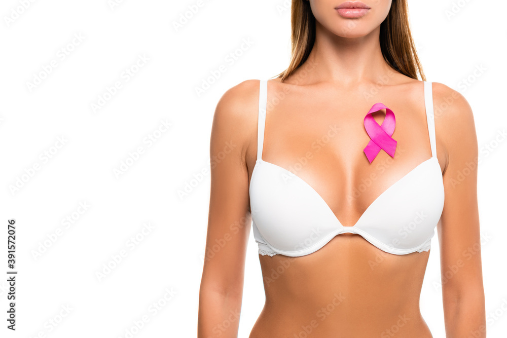 Cropped view of ribbon of breast cancer awareness on chest of woman in bra isolated on white Cropped view of ribbon of breast cancer awareness on chest of woman in bra isolated on white