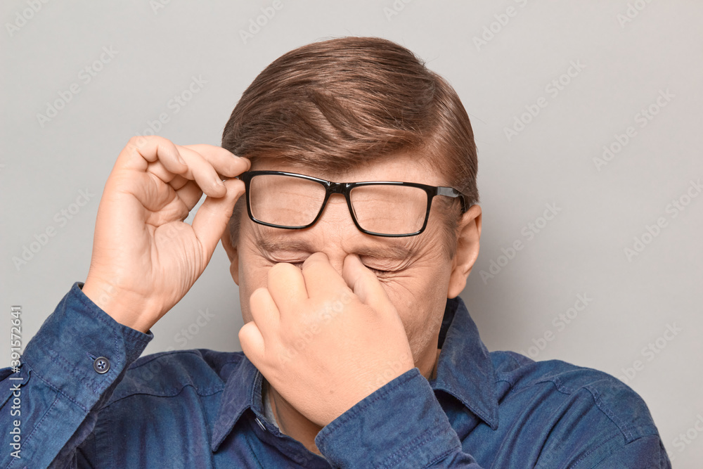 Portrait of unhappy tired man touching bridge of nose, squinting eyes Portrait of unhappy tired man touching bridge of nose, squinting eyes