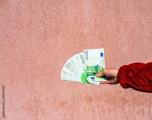 Hand holding and showing a fan of euro money or giving money. World money concept, 100 EURO banknotes EUR currency isolated. Concept of rich business people, saving or spending money. photo