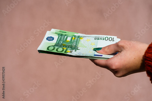 Hand holding and showing euro money or giving money. World money concept, 100 EURO banknotes EUR currency isolated. Concept of rich business people, saving or spending money. photo