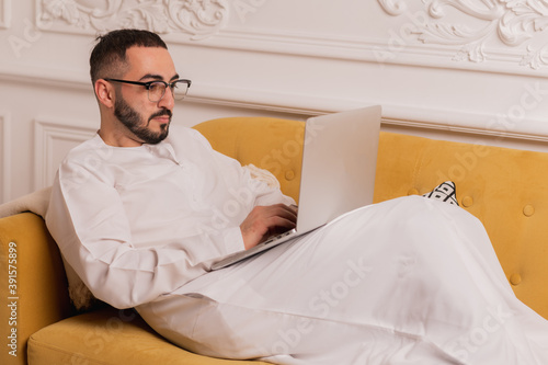 arabic programmer working on laptop at home