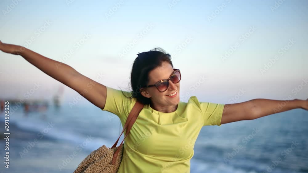Joyful brunette lady walking on evening seashore raising hands feeling freedom. 4k Dragon RED camera Joyful brunette lady walking on evening seashore raising hands feeling freedom. 4k Dragon RED camera