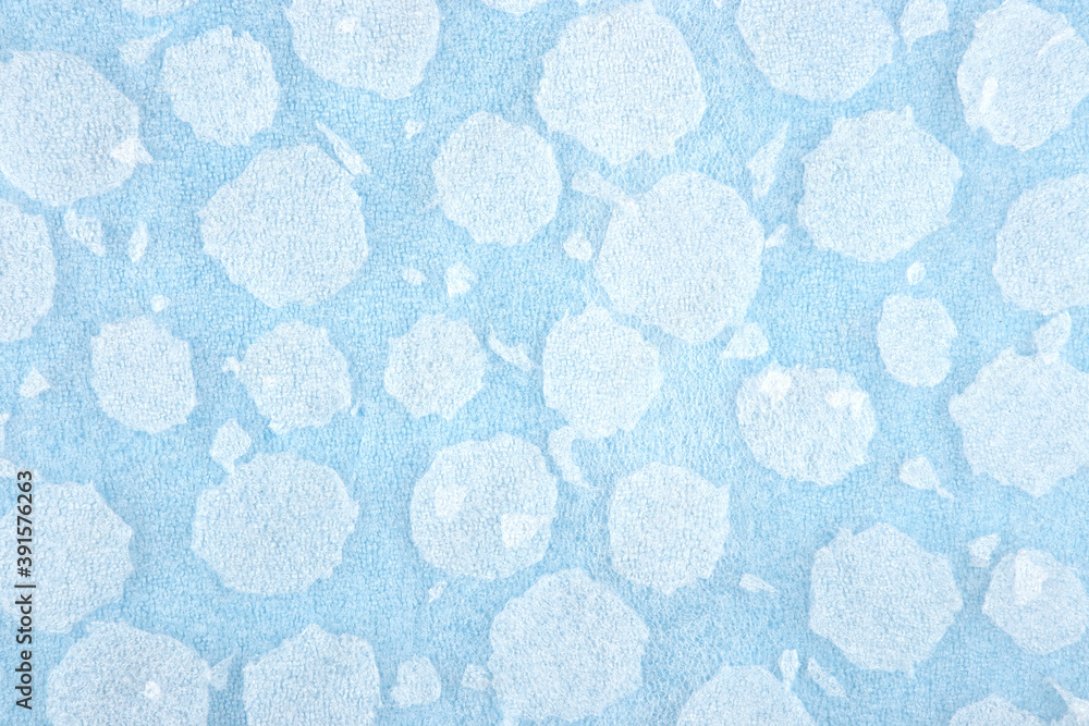 White round plastic foam sheet pieces on blue background. Winter snowfall concept. Torn foam polyethylene transparent pieces as snowflakes. White round plastic foam sheet pieces on blue background. Winter snowfall concept. Torn foam polyethylene transparent pieces as snowflakes.