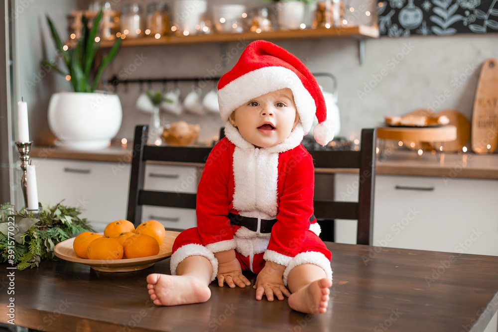 Baby Santa sits in the kitchen of the house, the inscription on a graphic board in Russian the language Baby Santa sits in the kitchen of the house, the inscription on a graphic board in Russian the language