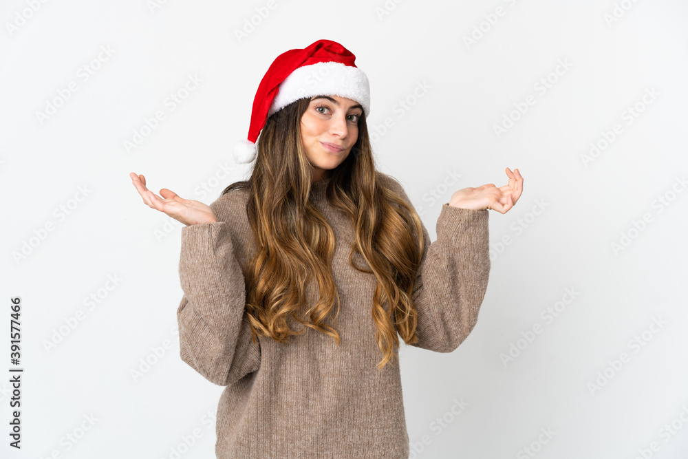 Caucasian girl with christmas hat isolated on white background having doubts while raising hands Caucasian girl with christmas hat isolated on white background having doubts while raising hands