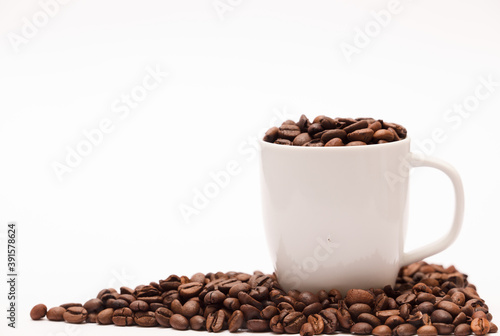 white ceramic cup, with coffee beans and white background