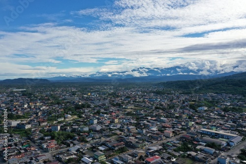 Aerial view over the city puyo, a city surrounded by tropical rainforest with a beautiful cloudscape and mountains in the background