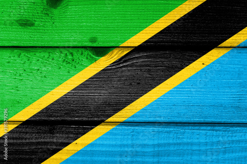 Tanzania flag painted on old wood plank background. Brushed natural light knotted wooden board texture. Wooden texture background flag of Tanzania