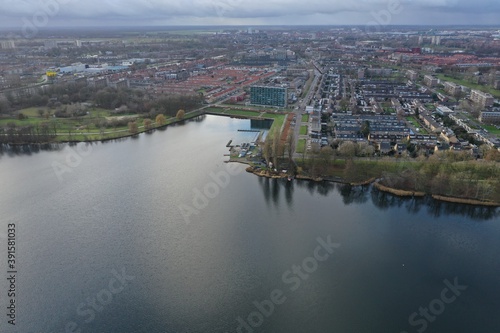 Aerial view over a city next to a lake in Europe with bare trees due to winter