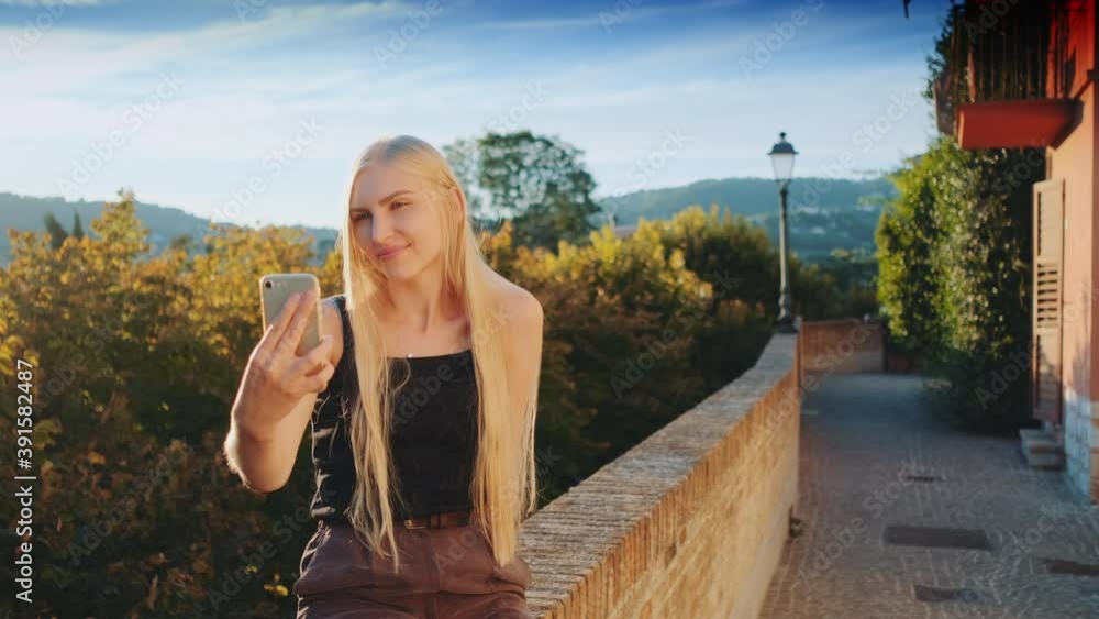 Pretty woman making selfie on smartphone in front of beautiful nature landscape. Summer trip to another country. Pretty woman making selfie on smartphone in front of beautiful nature landscape. Summer trip to another country.