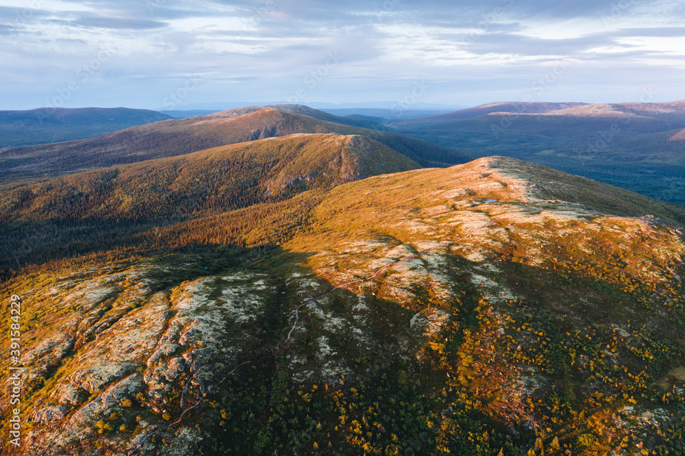 Autumn tundra landscape at sunset in mountains near Kandalaksha, aerial panoramic view. Wild nature scenery of Russian North. Kola Peninsula, Murmansk Oblast, Russia