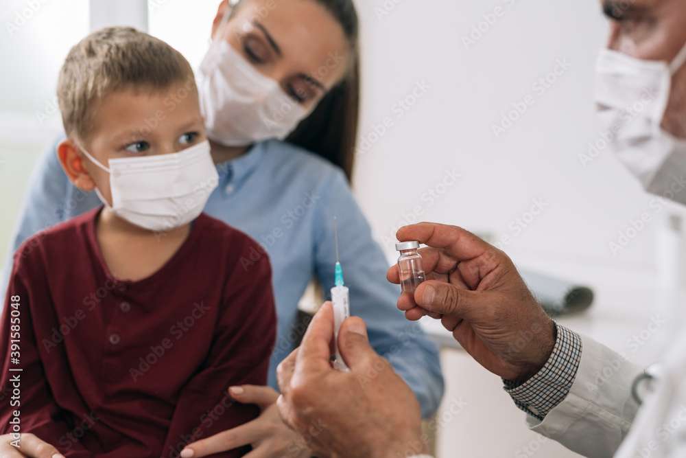 boy with his mother at the pediatrician receives coronavirus vaccine, boy with his mother at the pediatrician receives coronavirus vaccine,