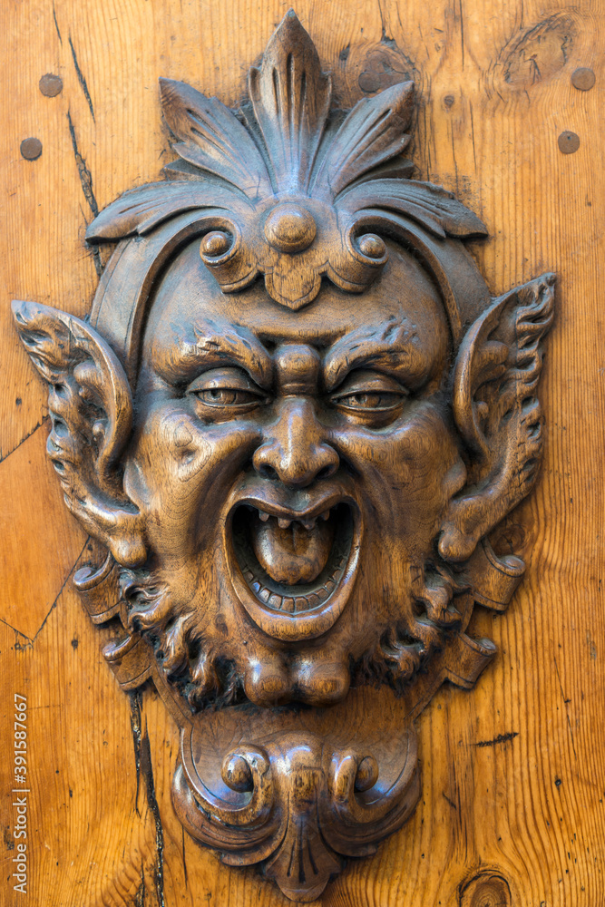 Teufelskopf als Skulptur an einer Holztür in Siena, Italien
