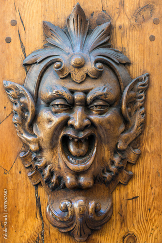 Teufelskopf als Skulptur an einer Holztür in Siena, Italien