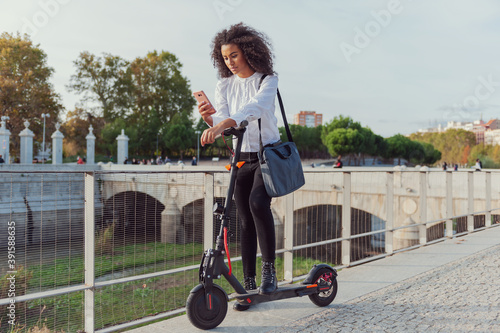 Young woman downloads the application to use the electric scooter in the city streets sustainable lifestyle