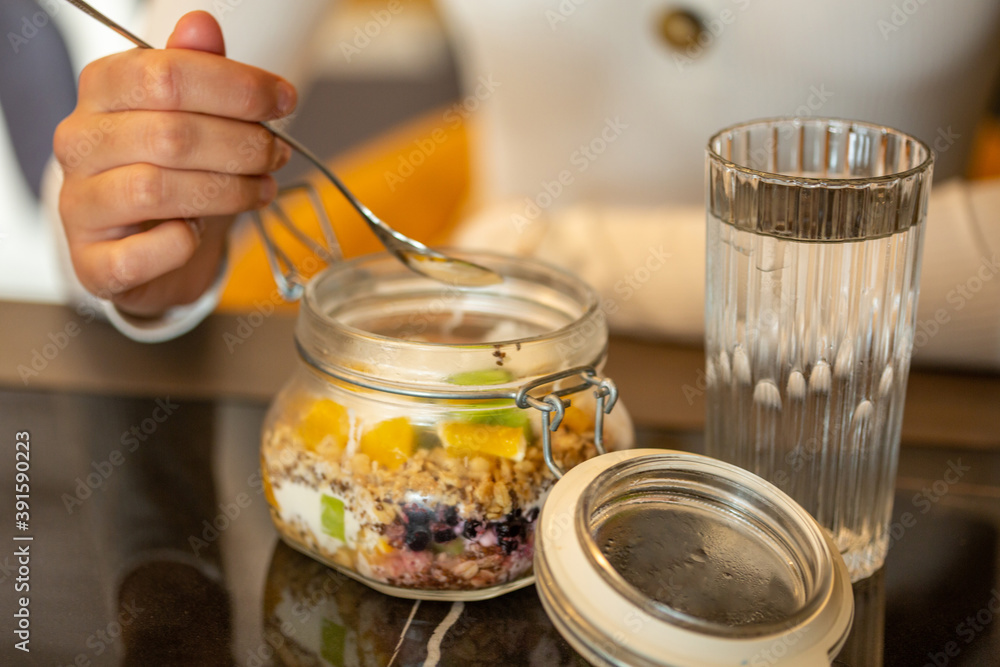 Woman eating healthy breakfast from a jar Woman eating healthy breakfast from a jar