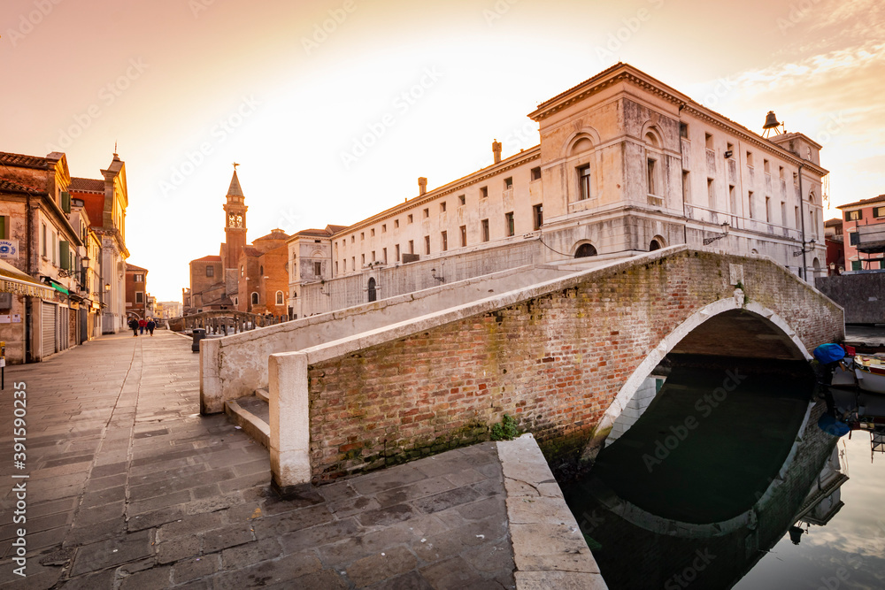 Obraz premium Romantic cityscape of Ghioggia - near Venice - with canals, buidings, bridges and canals in sunset sunlight. Bridge Dora and Cityhall