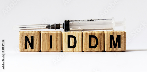 Text NIDDM made from wooden cubes. White background