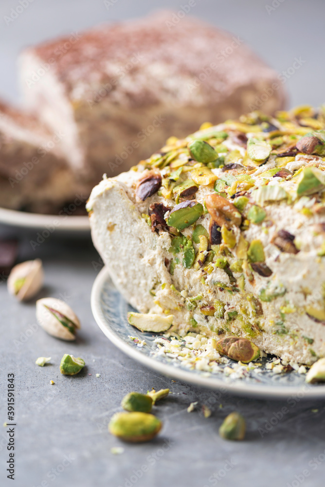 Sesame chocolate halva and halva with pistachios on grey background