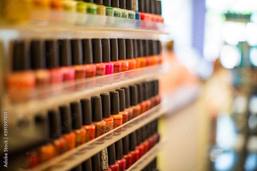 Rows of colorful nail polish line a wall.