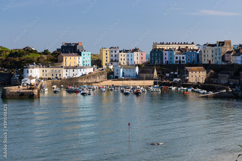 Obraz premium People around the harbour enjoying late summer sunshine in the picturesque Welsh seaside town of Tenby in Pembrokeshire