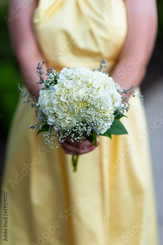 Young woman holding yellow flower bouque.
