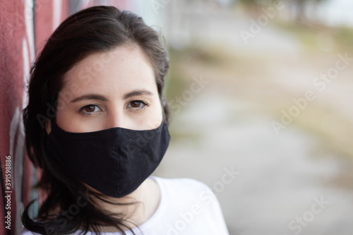 Mulher usando máscara por causa do isolamento social provocado pelo covid19