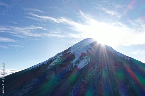 Summit of Chimborazo vulcano in Ecuador while the sun is coming up from behind photo