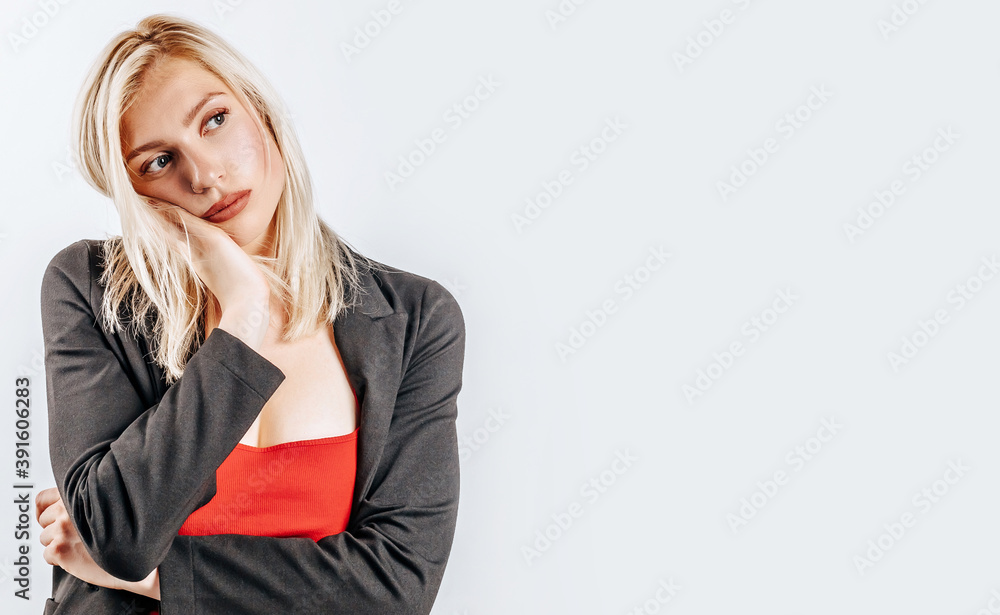 The woman thought about the choice and furrowed her eyebrows. Young beautiful blonde girl holds a hand to the face thinks and makes a decision. Place for advertising. What to choose The woman thought about the choice and furrowed her eyebrows. Young beautiful blonde girl holds a hand to the face thinks and makes a decision. Place for advertising. What to choose