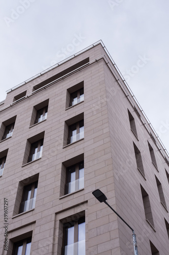 A minimalistic gray building in the center of Moscow. The sky is reflected in the windows in blue