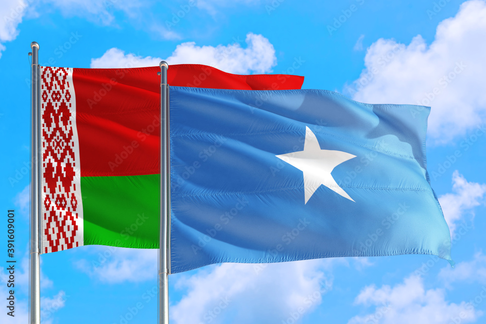 Naklejka premium Somalia and Belarus national flag waving in the windy deep blue sky. Diplomacy and international relations concept.