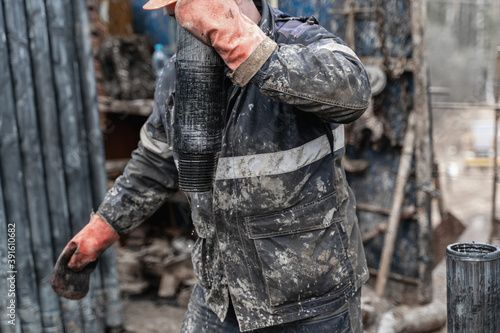 Offshore oil rig worker prepare tool and equipment for perforation oil and gas well at wellhead platform. Making up a drill pipe connection. A view for drill pipe connection from between the stands