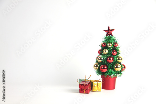 Decorated Christmas tree and apile of gifts isolated on white background